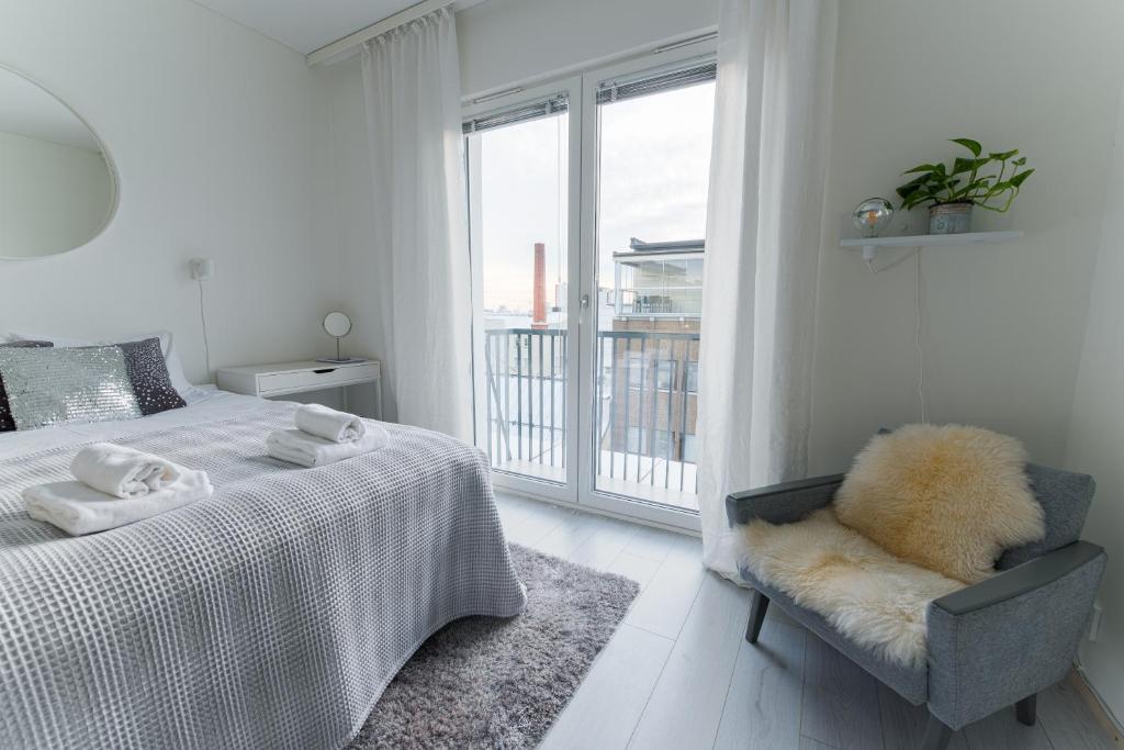 una camera da letto con un letto, una sedia e una finestra di Compact high quality top floor studio in perfect location a Oulu