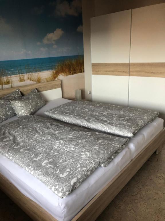 ein Bett mit einer silbernen Bettdecke und einem Strand in der Unterkunft Ferienwohnung Bergkristall in Forchheim