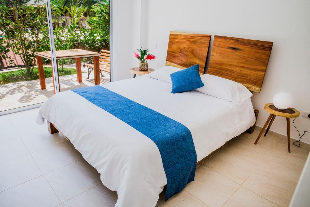 a bedroom with a large bed with a blue pillow at Hotel Restaurante Selva Negra in Turbaco