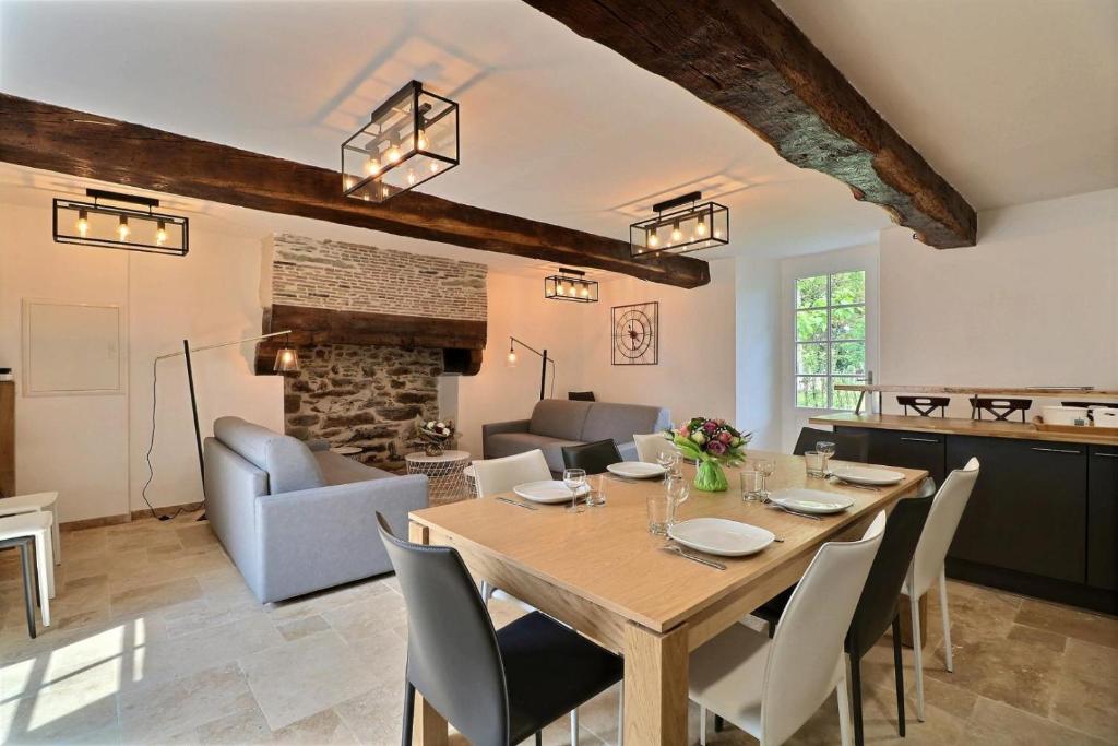 a dining room and living room with a table and chairs at Chateau des Fontenelles in Chavagne