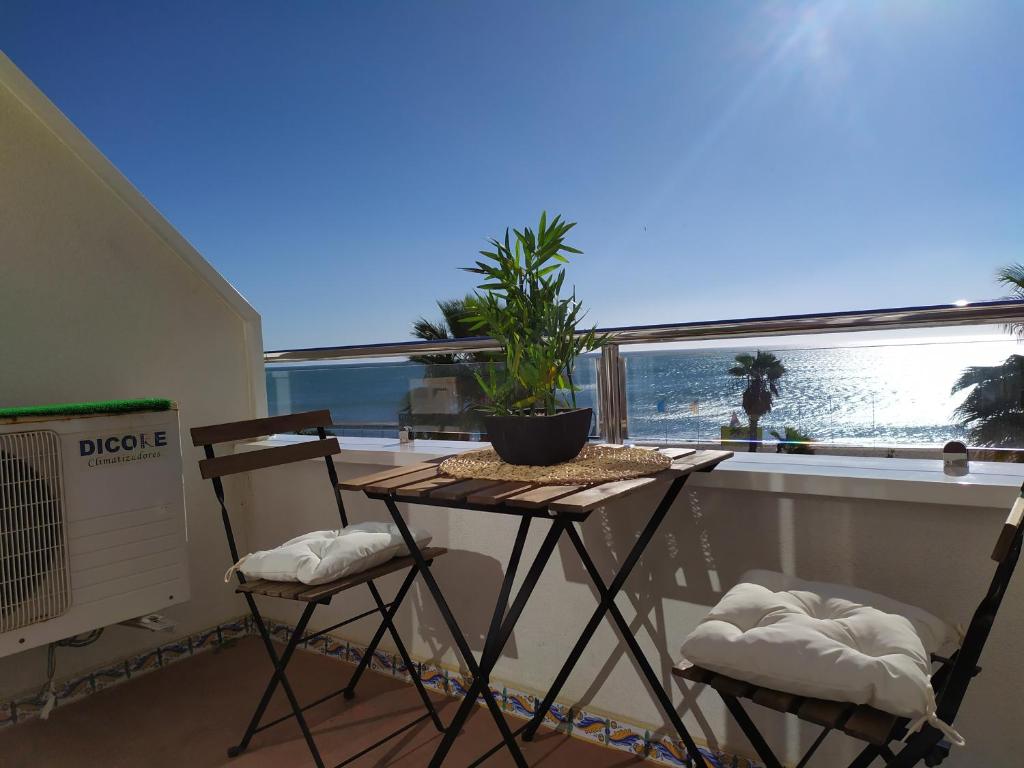 balcón con mesa y 2 sillas frente a una ventana en Bajondillo Sun & Beach, en Torremolinos
