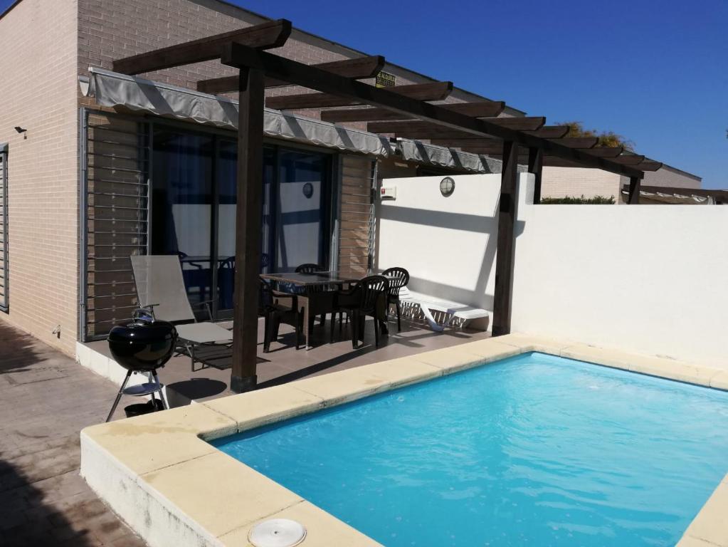 een zwembad met een pergola en een tafel bij Casa en Bassetes LOCDENIA in El Verger