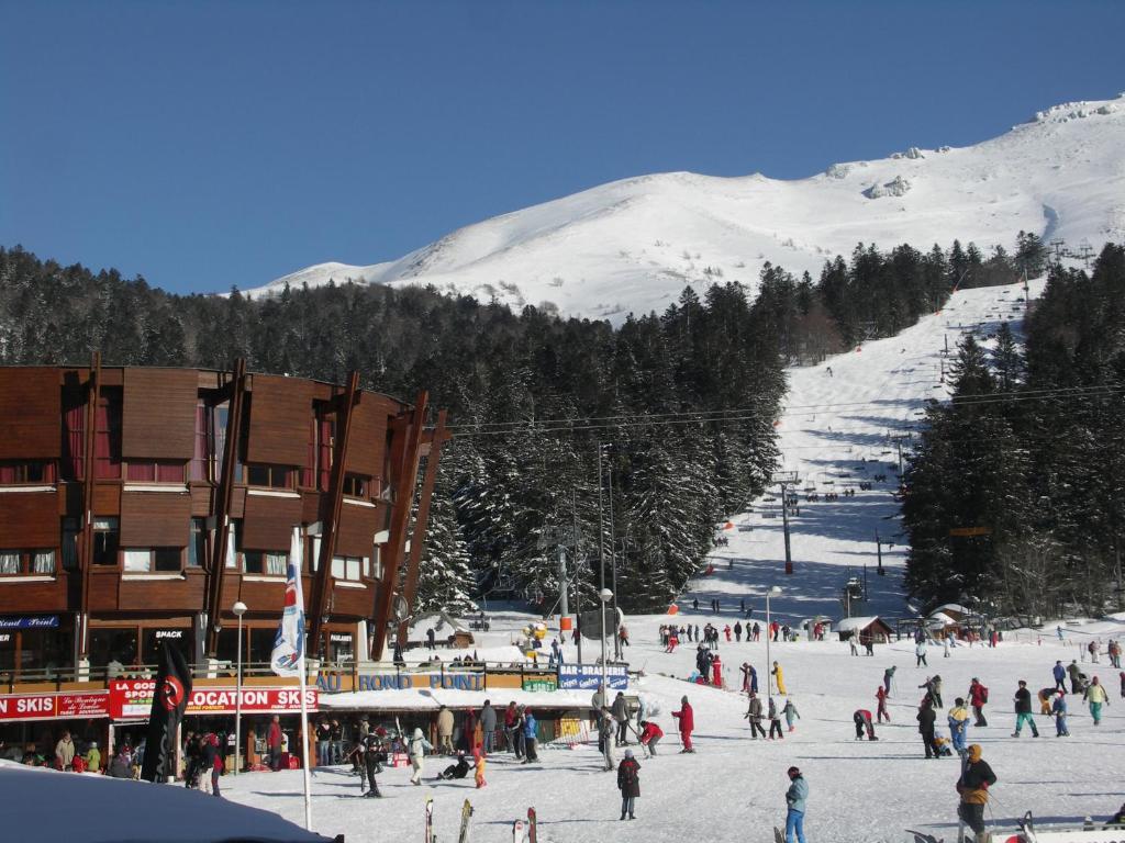 un groupe de personnes sur une piste de ski enneigée dans l'établissement LE SAPORTA- Studios et Appartements meublés de tourisme, à Le Lioran