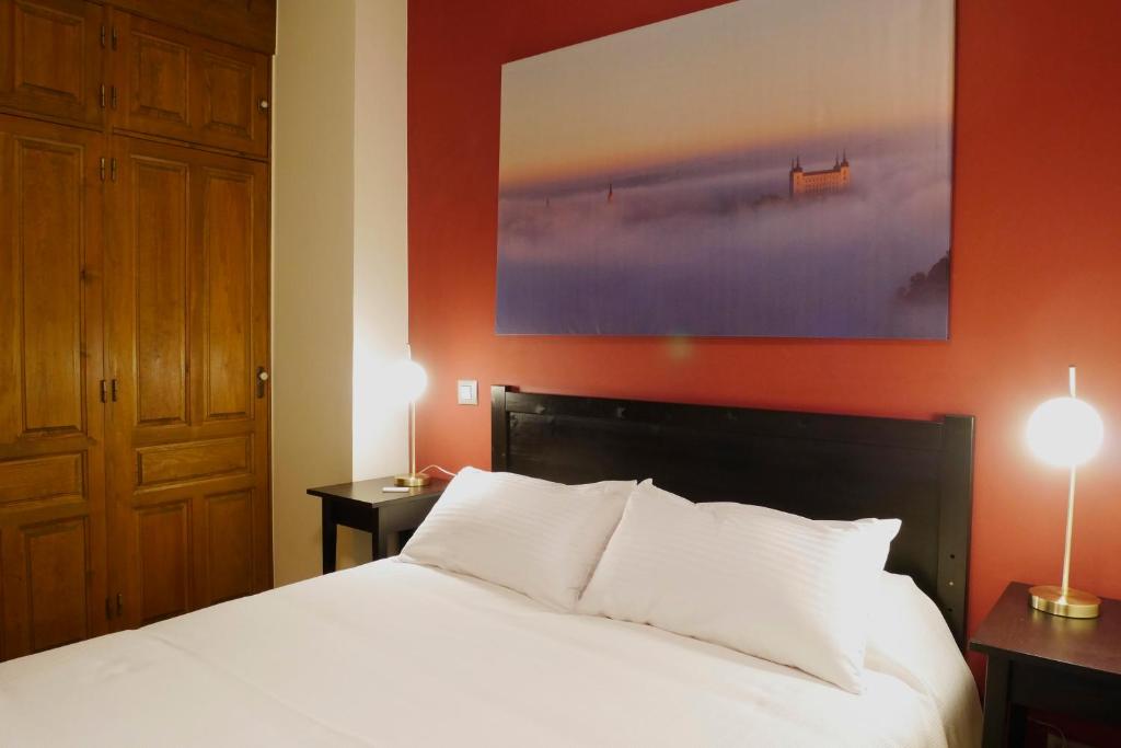 een slaapkamer met een bed en een groot schilderij aan de muur bij Apartamento El Arco in Toledo
