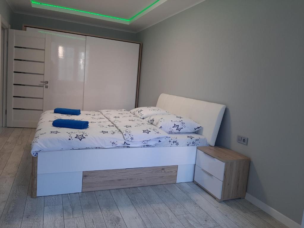 1 dormitorio con cama blanca y armario de madera en Люкс 2 en Úzhgorod