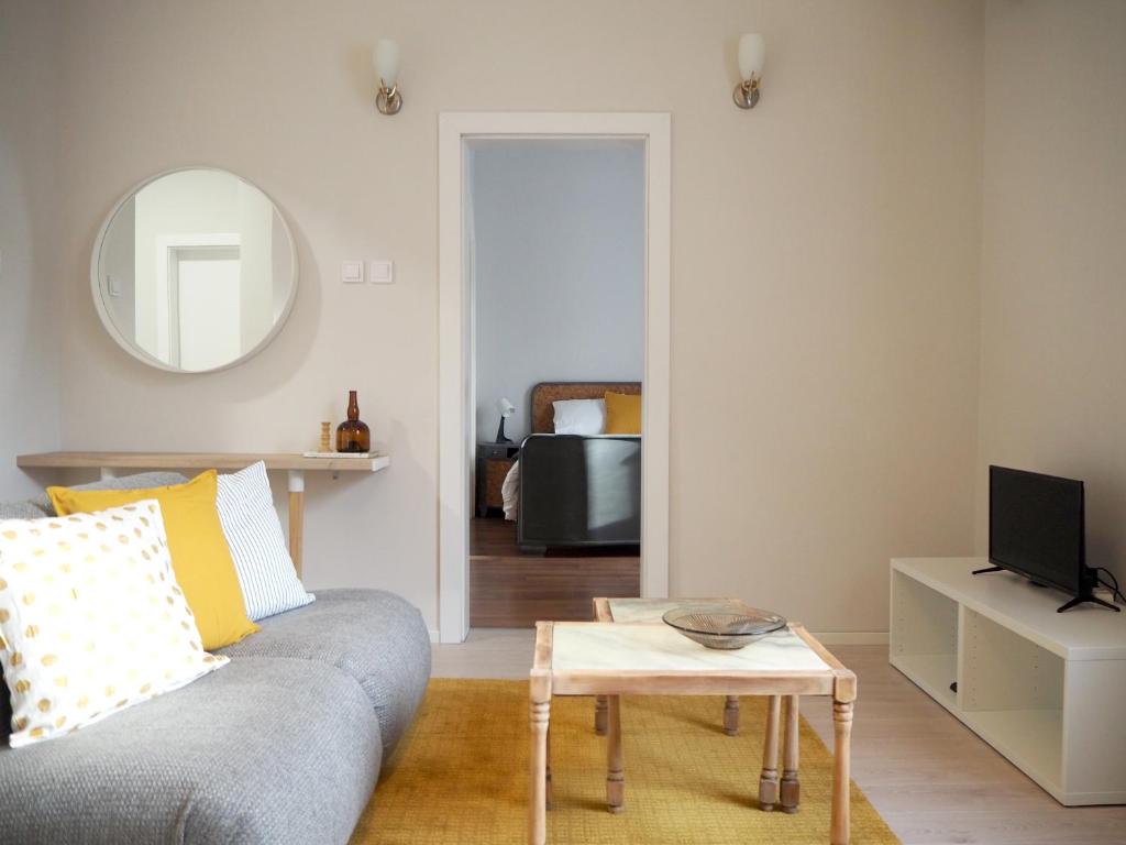 uma sala de estar com um sofá e um espelho em Caché ✦ Bright One-Bedroom Apartment in Sofia em Sófia