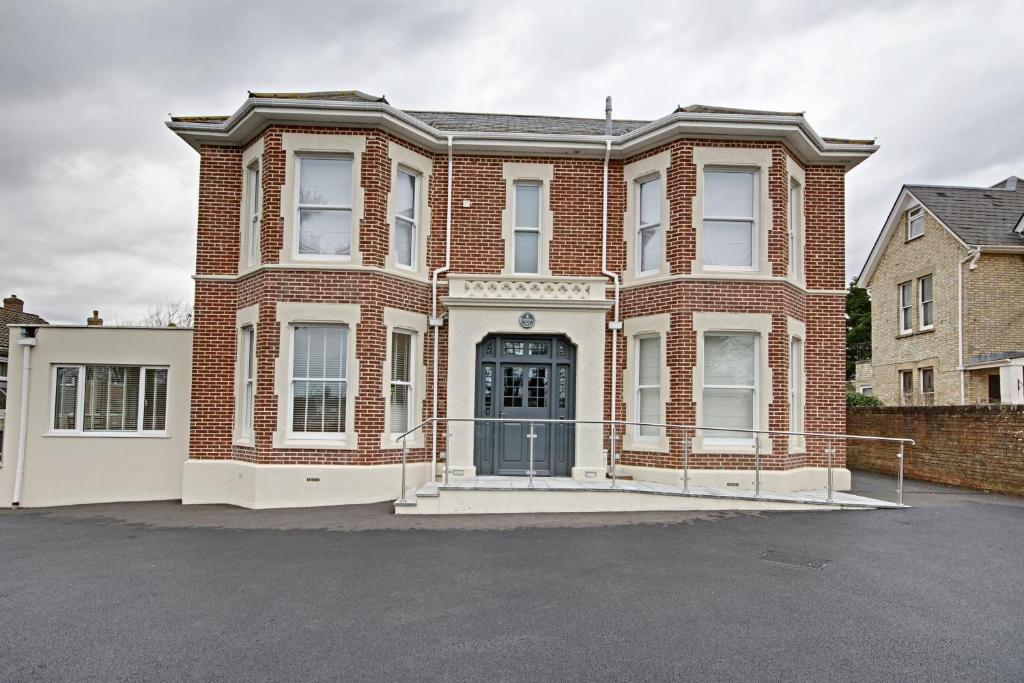 a brick house with a gate in a parking lot at Highfield Bed & Breakfast in Lymington