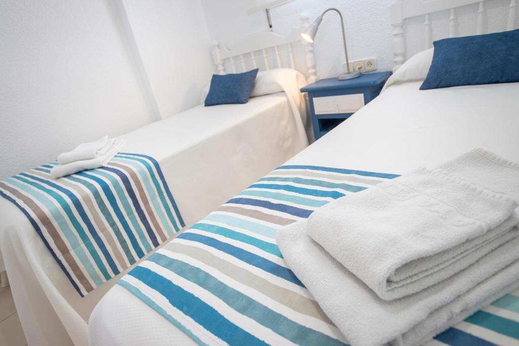two beds in a hospital room with towels on them at Apartamentos BCL Playa Albir in Albir