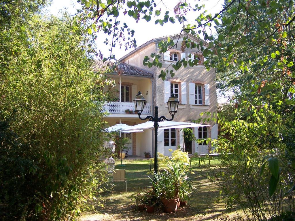 una casa blanca con una luz de la calle delante de ella en Domaine de Las Planques, en Vaudreuille