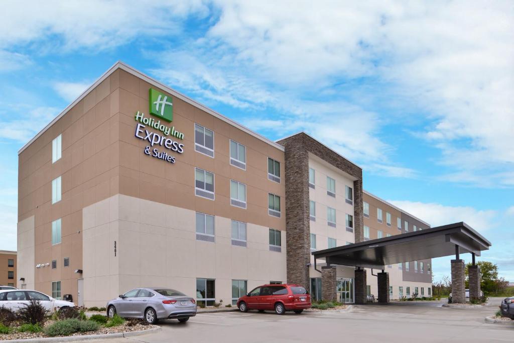 un edificio alberghiero con auto parcheggiate in un parcheggio di Holiday Inn Express & Suites - Marshalltown, an IHG Hotel a Marshalltown