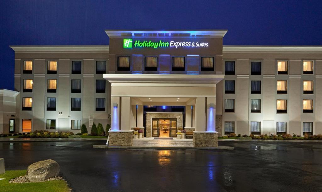 un hotel frente a un edificio por la noche en Holiday Inn Express & Suites Malone, an IHG Hotel, en Malone