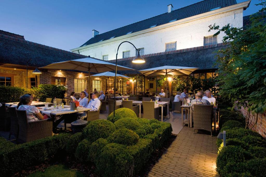 a group of people sitting at tables in a restaurant at Auberge l'Entrecôte in Kluisbergen