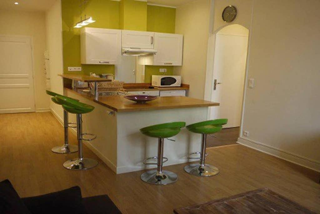 a kitchen with green bar stools and a counter at Barla 3 - a spacious one bedroom apartment near Place Garibaldi in Nice