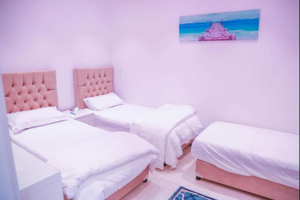 a room with two beds and a painting on the wall at Happiness Chalet 512 in Jeddah