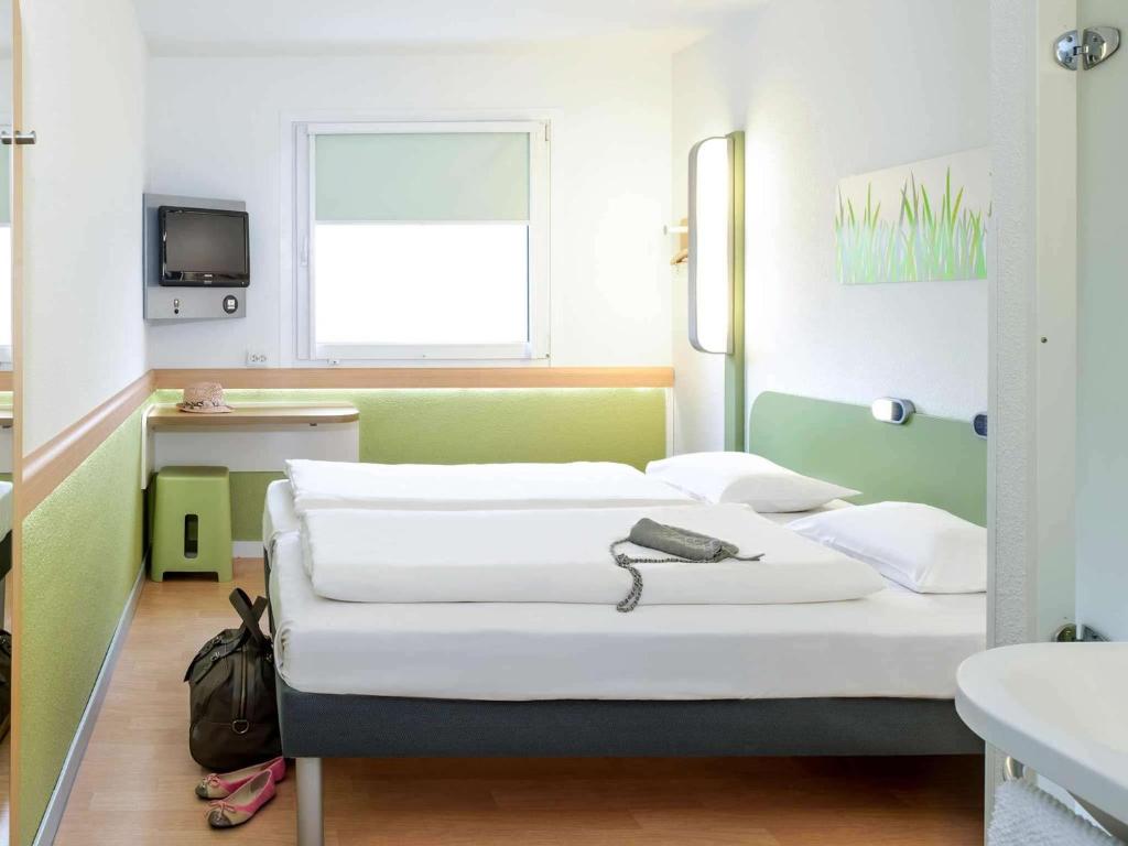 Postel nebo postele na pokoji v ubytování ibis budget Augsburg Gersthofen