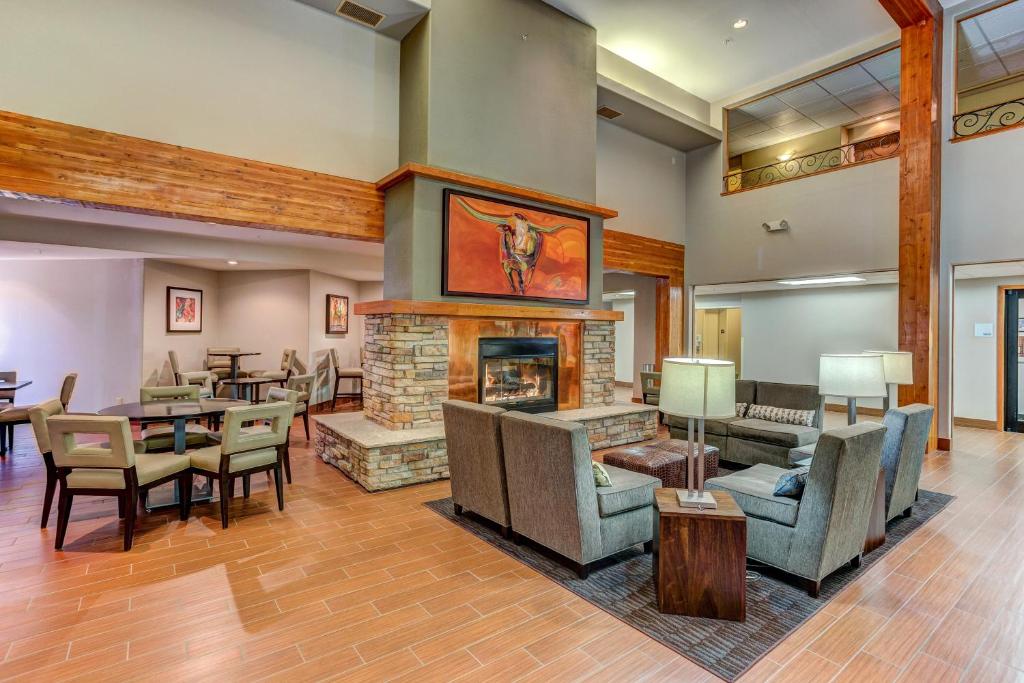 un soggiorno con camino, tavoli e sedie di Holiday Inn Express Hotel & Suites Montrose - Black Canyon Area by IHG a Montrose