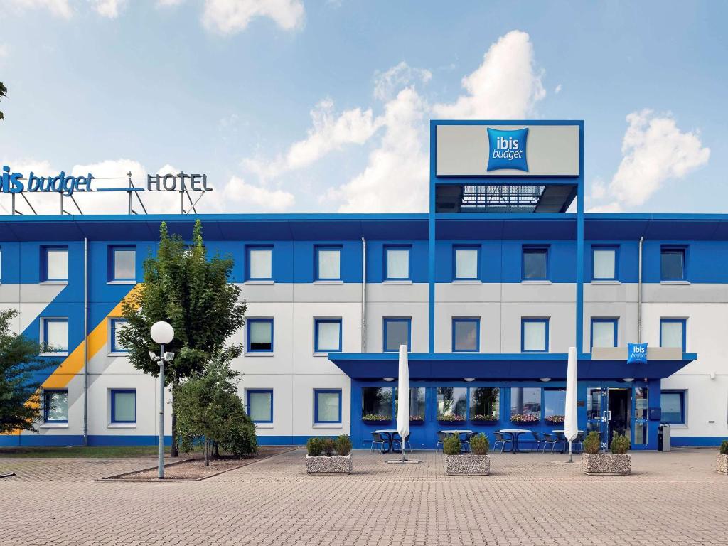 un edificio azul y blanco con un cartel en él en ibis budget Berlin Hoppegarten, en Hoppegarten