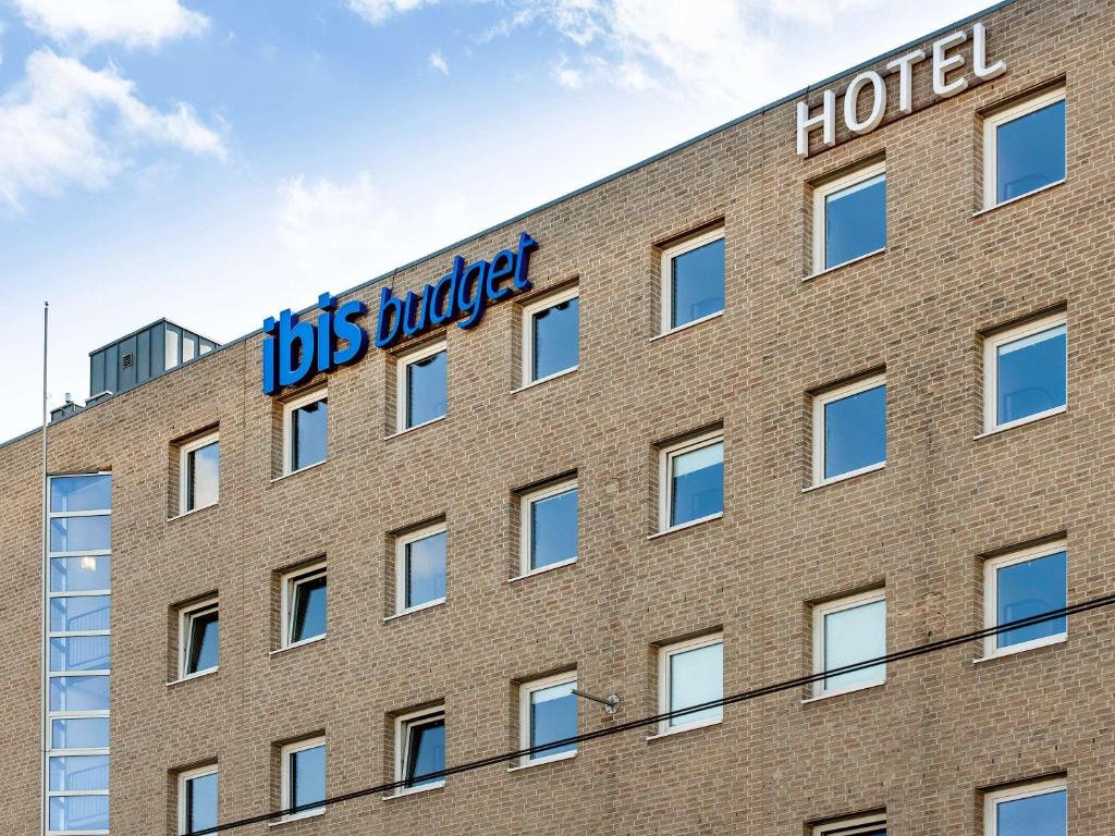 ibis budget Krefeld Messe-Düsseldorf في كريفيلد: مبنى من الطوب عليه علامة