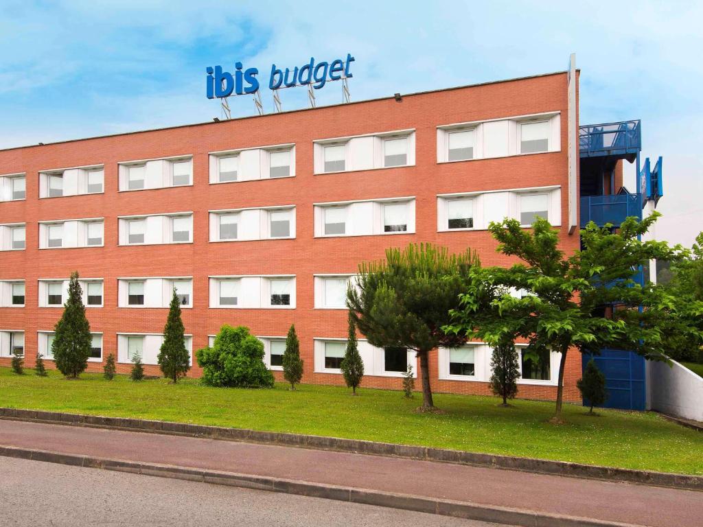 ein rotes Gebäude mit einem Schild darüber in der Unterkunft Ibis Budget Bilbao Arrigorriaga in Arrigorriaga