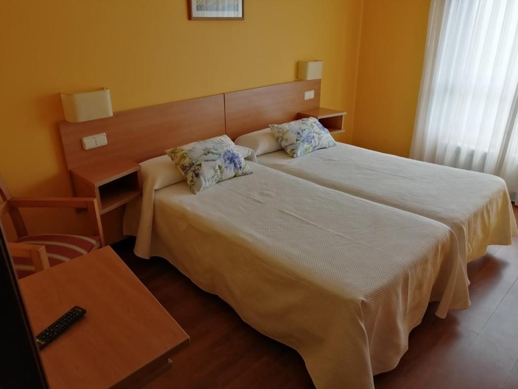 PontecesoにあるPensión Teymaのベッドルーム1室(ベッド1台、デスク、ベッド1台付)