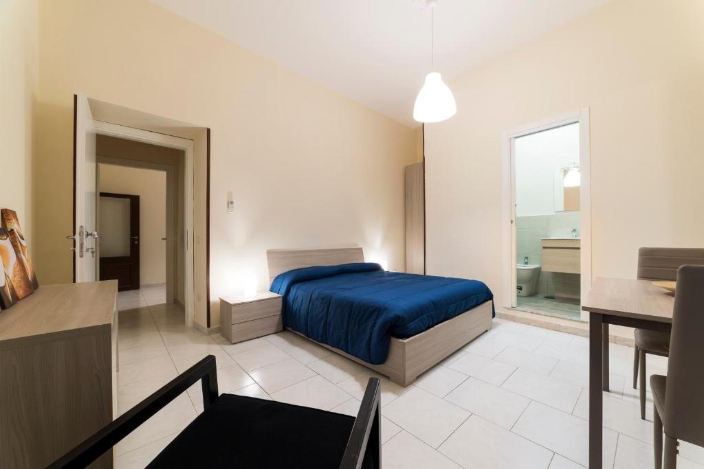 1 dormitorio con cama azul y baño en Casa del Pescatore, en Castellammare di Stabia