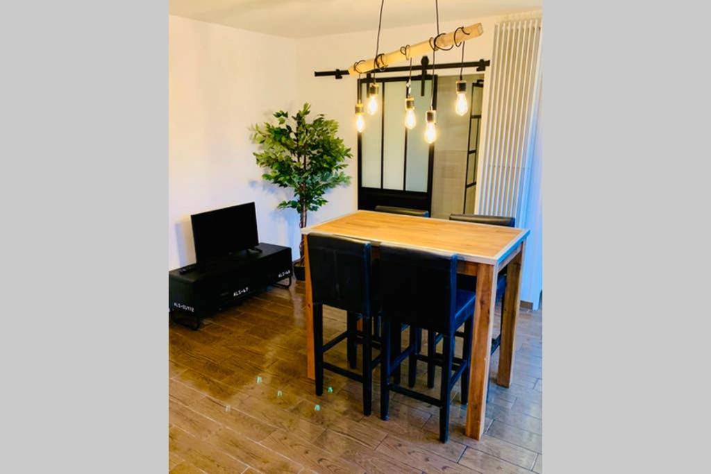 a dining room with a wooden table and chairs at Studio centre de Hyeres pour 4 personnes piscine et tennis in Hyères