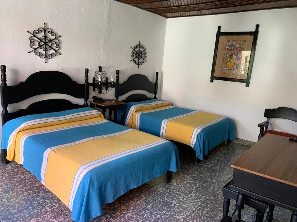 Postel nebo postele na pokoji v ubytování Hotel Villa de Flores