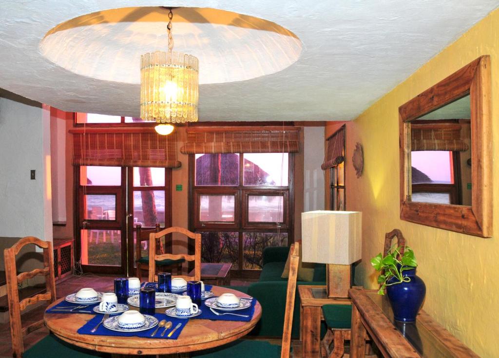 una sala da pranzo con tavolo e lampadario pendente di Villas El Rancho Green Resort a Mazatlán