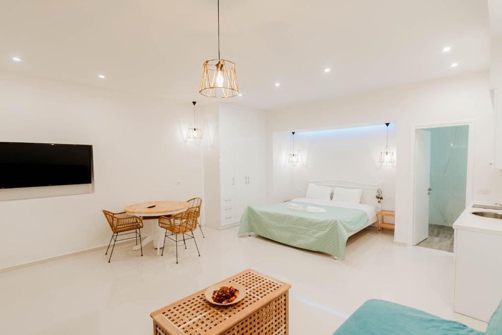 a white living room with a bed and a table at Annas Apartment in Parga