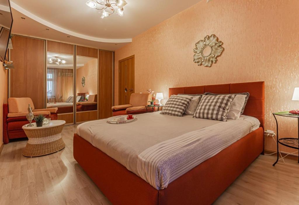 ニジニ・ノヴゴロドにあるУютная квартира с качелями на верандеのベッドルーム(大型ベッド1台付)、リビングルームが備わります。