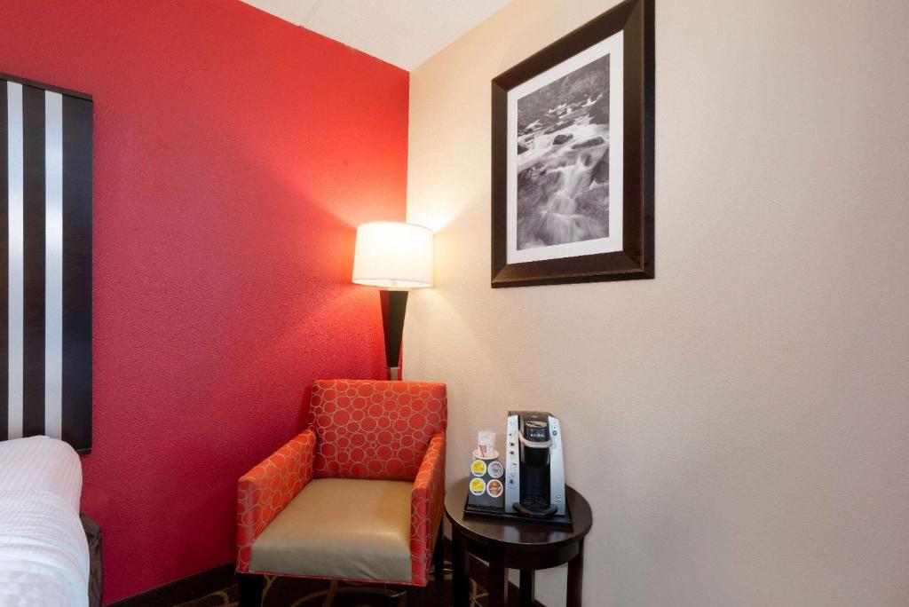 a room with a bed and a chair and a lamp at La Quinta Inn & Suites - New River Gorge National Park in Summersville