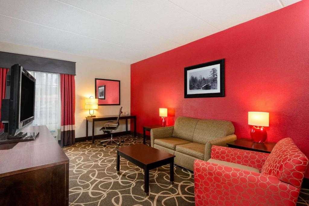 a living room with a couch and a tv at La Quinta Inn & Suites - New River Gorge National Park in Summersville