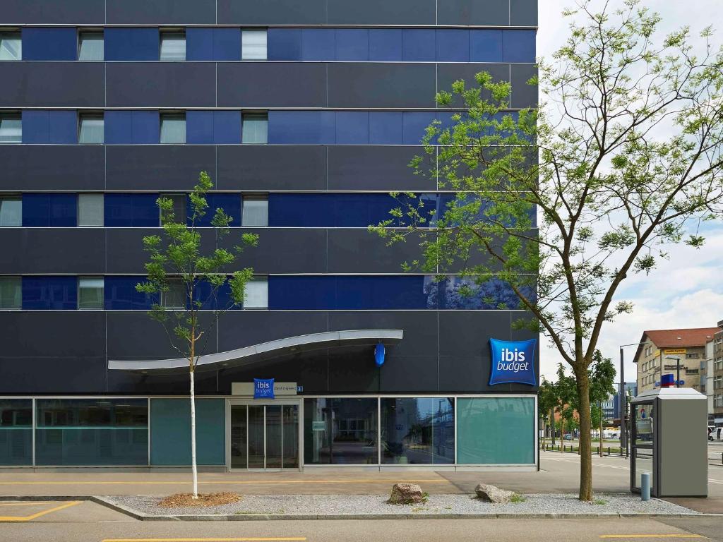 ein großes blaues Gebäude mit einem Bankschild drauf in der Unterkunft ibis budget Zurich City West in Zürich