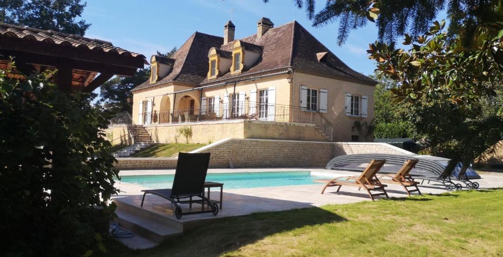 une maison avec une piscine devant dans l'établissement La noyeraie du port d'enveaux, à Saint-Vincent-de-Cosse