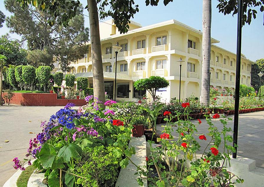 a large building with flowers in front of it at Ritz Plaza in Amritsar