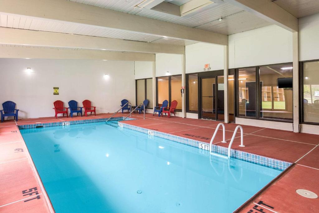 una gran piscina con sillas rojas en un edificio en Fairmount Inn & Suites - Stroudsburg, Poconos en Delaware Water Gap