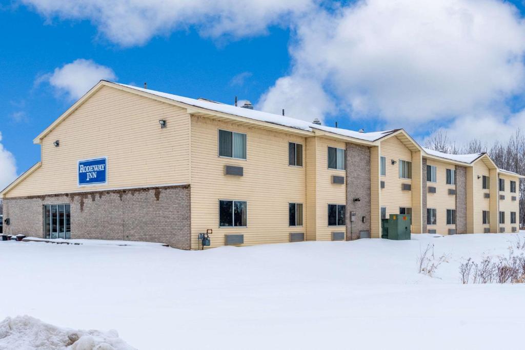 een groot gebouw met sneeuw ervoor bij Rodeway Inn in Milaca