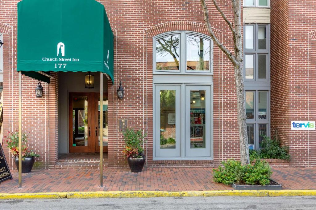 a brick building with a green awning on it at Church Street Inn, Ascend Hotel Collection in Charleston