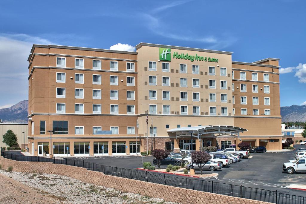un hotel con coches estacionados en un estacionamiento en Holiday Inn & Suites Albuquerque-North I-25, an IHG Hotel, en Albuquerque
