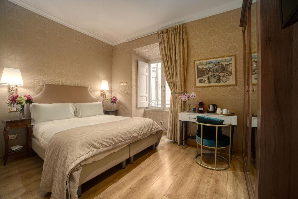 - une chambre avec un grand lit et un bureau dans l'établissement BQ House Trevi Luxury Rooms, à Rome