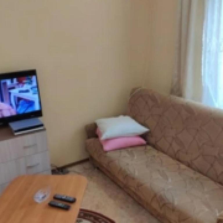 a living room with a couch and a tv at Хостел 24 in Vinnytsya