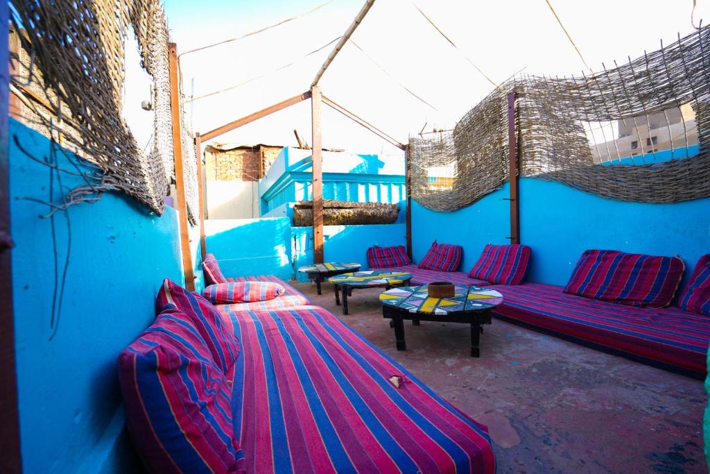 a living room with purple couches and a blue wall at Dahab Hostel in Cairo