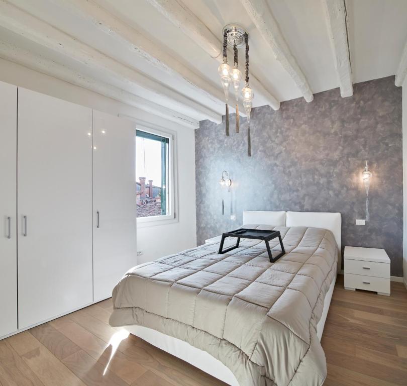 Un dormitorio con una cama grande y una mesa. en Classy Venice, en Venecia