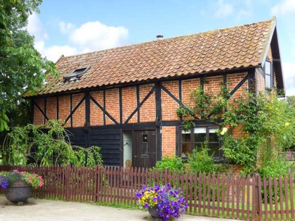 una piccola casa con una recinzione di fronte di The Granary a Norwich