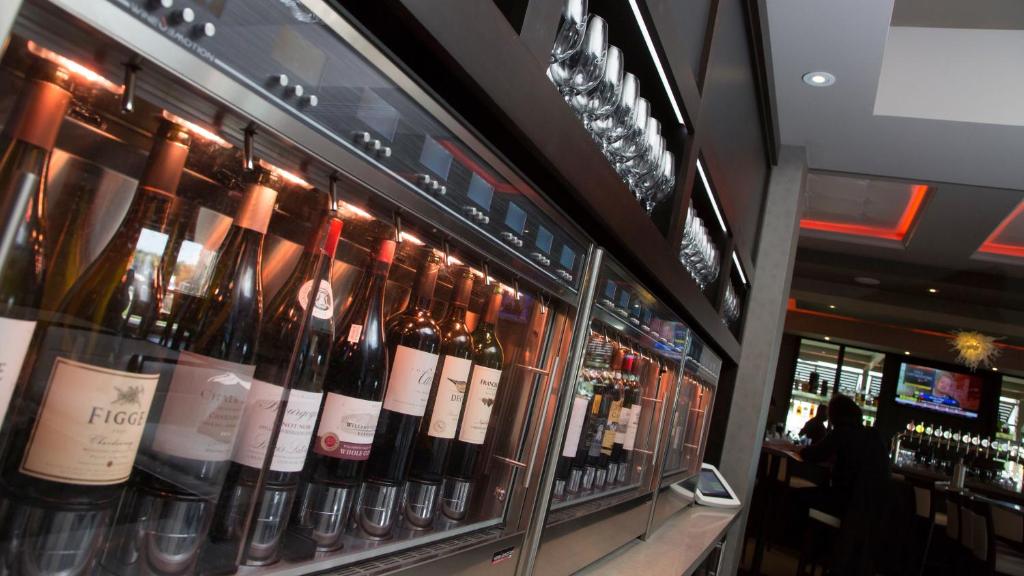 une vitrine de bouteilles de vin dans un bar dans l'établissement Holiday Inn Hotel & Suites Davenport, an IHG Hotel, à Davenport