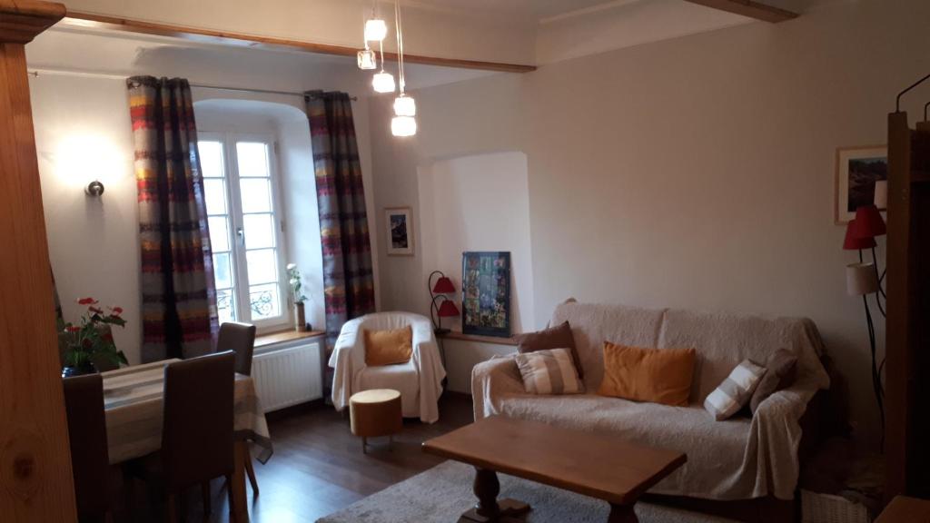 a living room with a couch and a table at L étoile du verger in Barcelonnette