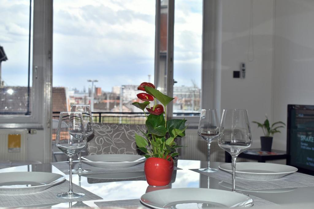 een tafel met glazen en een vaas met een bloem erop bij Apartment Tino in Zagreb