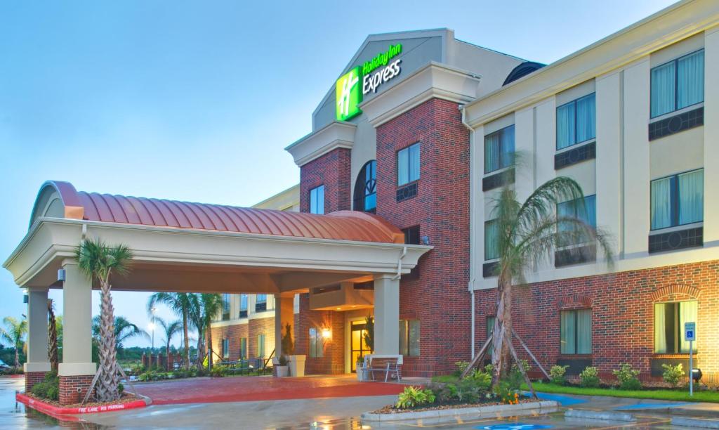 a hotel with a sign on the front of it at Holiday Inn Express Hotel & Suites Winnie, an IHG Hotel in Winnie