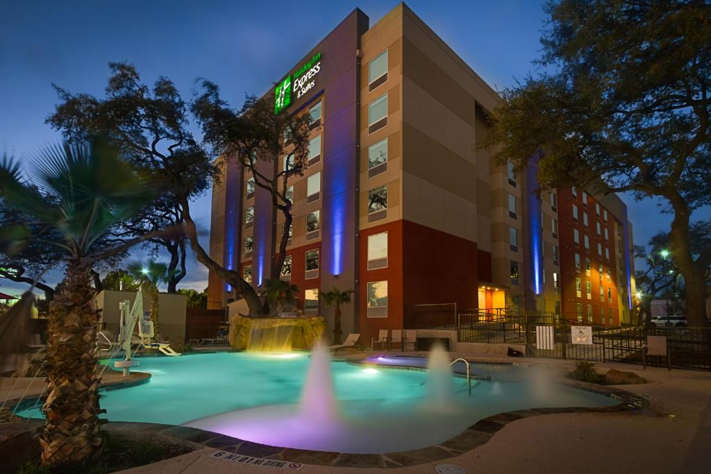 un hôtel avec une piscine en face d'un bâtiment dans l'établissement Holiday Inn Express & Suites San Antonio Medical Center North, an IHG Hotel, à San Antonio
