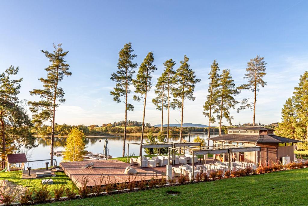 a house on the water with a dock at Lipno - Lakeside Village - Větrník in Frymburk